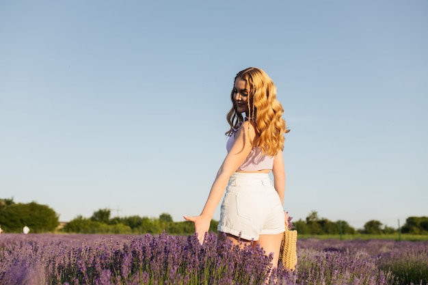 Meisje in een lavendelveld Vrouw in een veld met lavendelbloemen bij zonsondergang in een witte jurk Frankrijk Provence