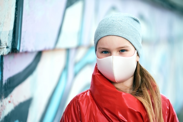 Meisje in een poederachtig masker en in een rode jas