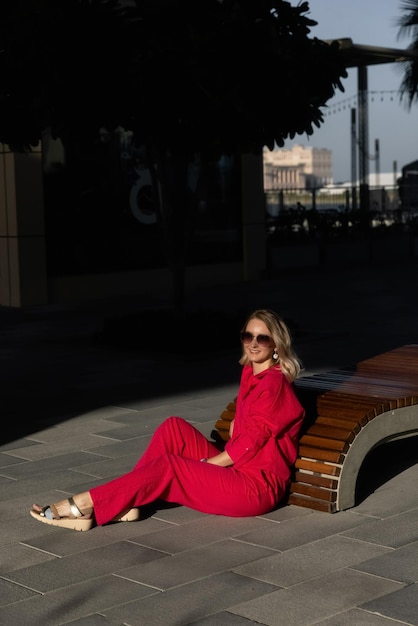 meisje in een rood pak op straat zonnebril