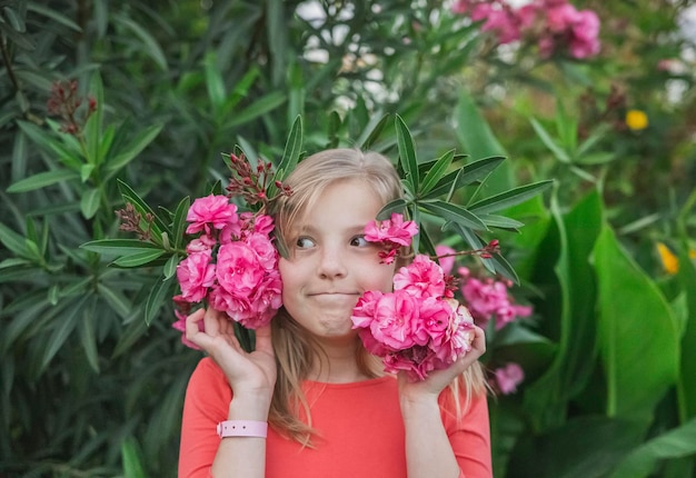 Foto meisje in een roze jurk lacht in bloemen