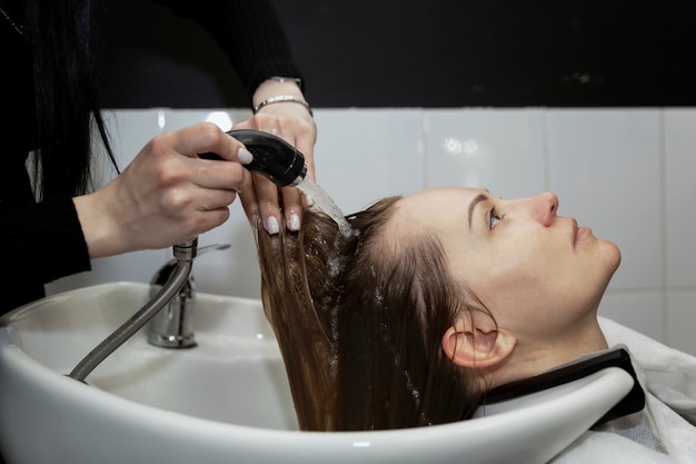 Meisje in een schoonheidssalon wassen hun haar in de gootsteen. Detailopname.