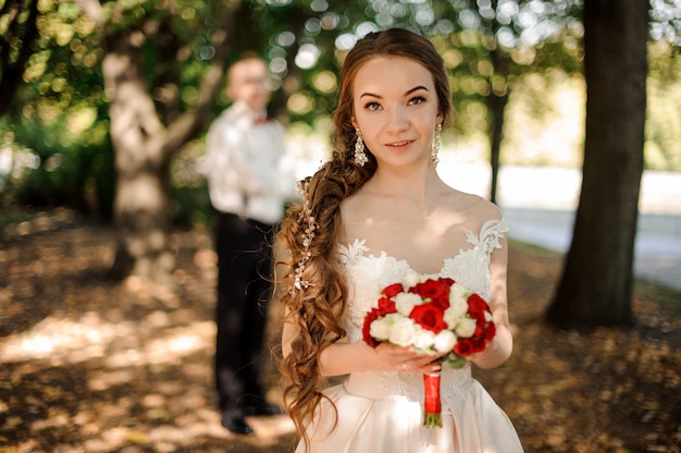 Meisje in een trouwjurk met een boeket bloemen