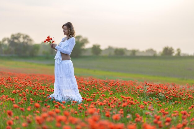 Meisje in een witte jurk in het papaverveld