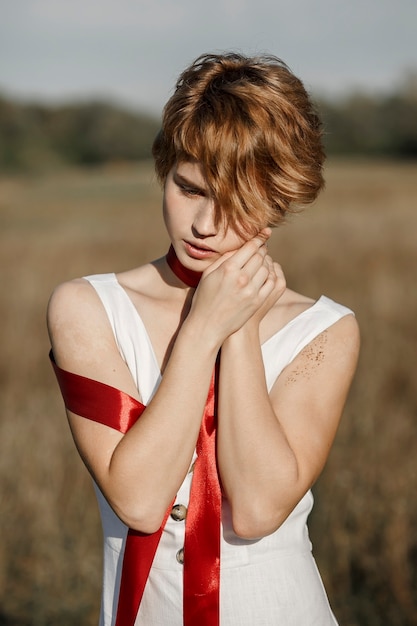 Meisje in een witte jurk met een rood lint