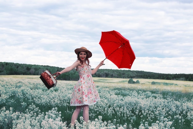 Meisje in een zomerweide met witte bloem in bewolkte dag