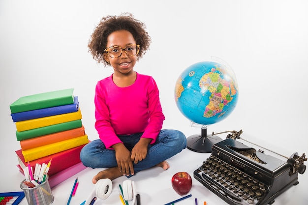 Meisje in glazen met studiehulpmiddelen in studio