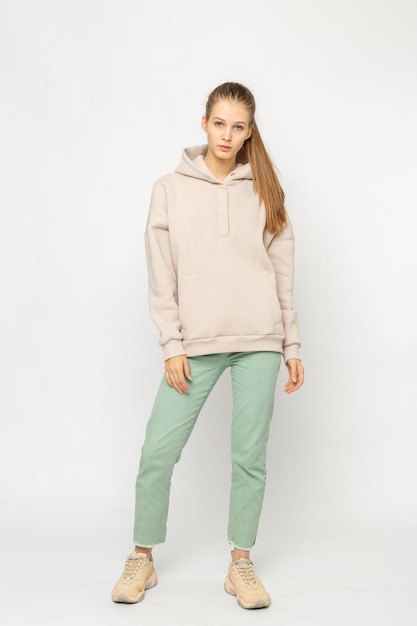 Meisje in groene cargo broek en beige hoodie geïsoleerd op wit