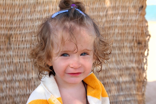 Meisje in handdoek op strand