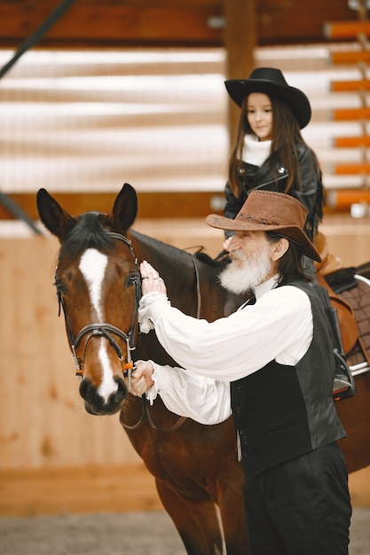 Meisje in helm leren paardrijden. Instructeur leert klein meisje.