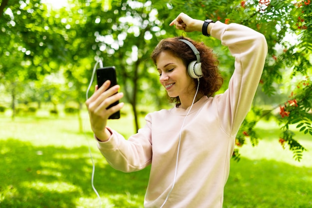 meisje in het park geniet van muziek in een koptelefoon in een stadspark