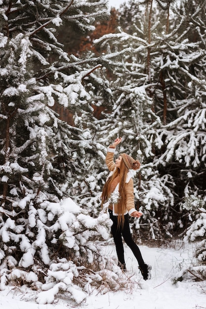 Meisje in het winterbos met sneeuw