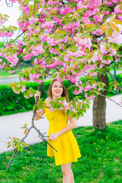 Meisje in jurk poseren met tak bloemen