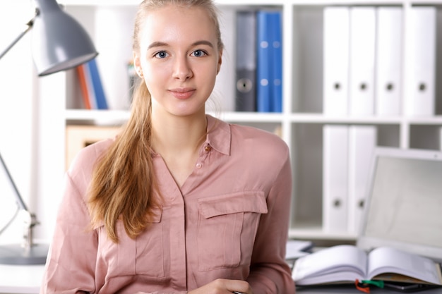 Foto meisje in kantoor op achtergrond mappen en boeken