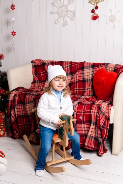 Meisje in Kerstdag met paard speelgoed