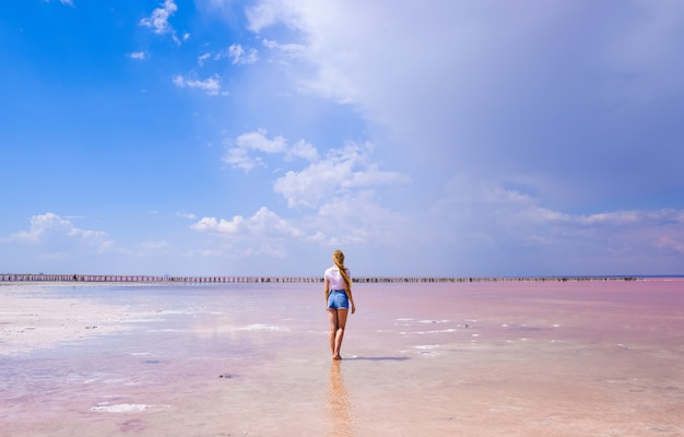 Meisje in korte broek en t-shirt op een zout roze meer in zonnige zomerweer