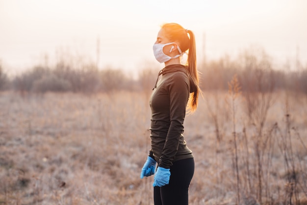 Foto meisje in masker en blauwe handschoenen tijdens quarantaine ging rennen