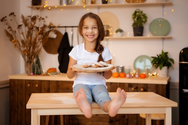 Meisje in pyjama's in de keuken met koekjes