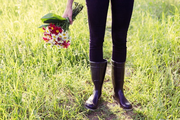 Meisje in regenlaarzen met bloemen