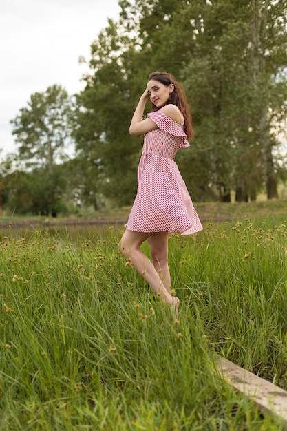 Meisje in rode jurk op de natuur in de zomer Portret van een mooi meisje in de zomer in het bos