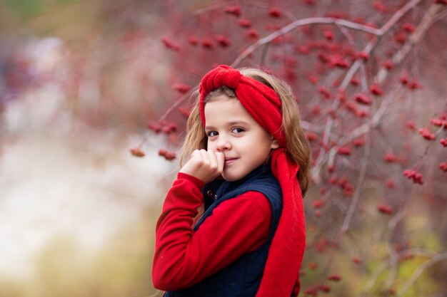 meisje in rode outfit in herfst bos