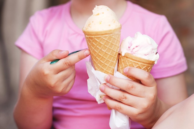 Meisje in roze jurk die ijs eet bij warm weer