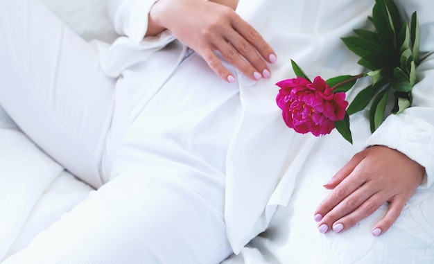 Meisje in witte broek en jassen en een bloem