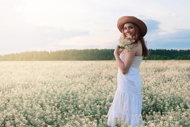 Meisje in witte jurk op een gebied van gele bloemen bloeien