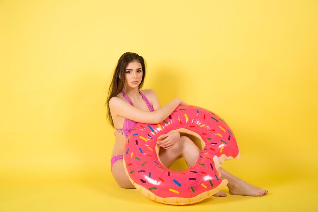 Meisje in zomer badmode badpak met donut lilo opblaasbare matras.