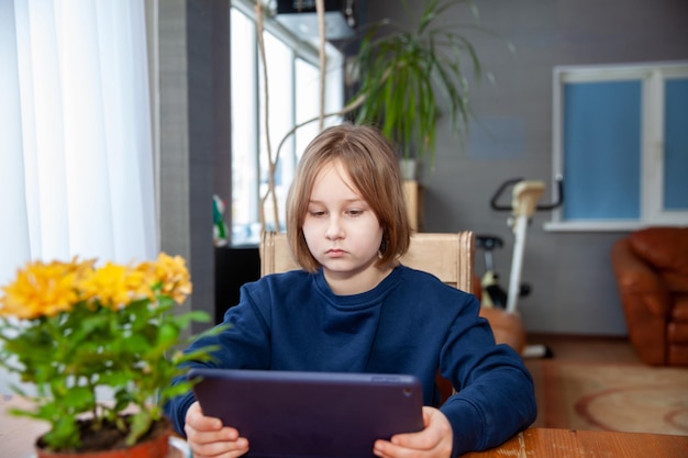 Meisje is verloofd op een tablet aan tafel