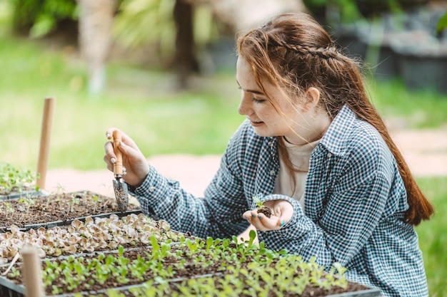 Foto meisje jonge tiener groeiende plant boom in de tuin schattig heerlijk