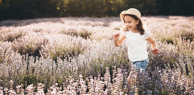 meisje juichen en loopt door een lavendelveld tijdens een zonnige zomerdag