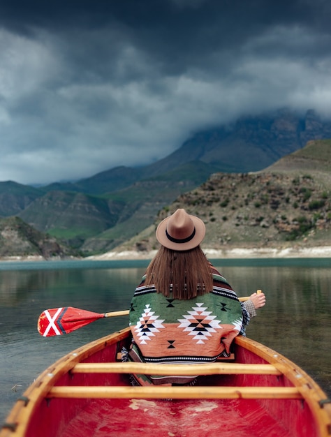 meisje kanoën op een meer in de bergen op een bewolkte dag humeurige sfeer op het meer van bylym