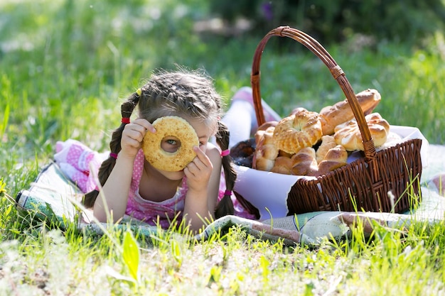 Foto meisje kijkt door donuts terwijl ze in het park ligt.