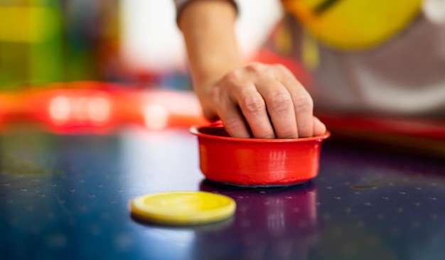 Meisje kind hand spelen tafelhockey met kleurrijke shai bij speeltuin park kind tijdens entertainment