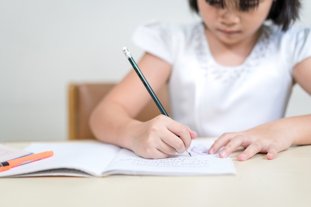 Meisje kinderen student schrijven op notebook huiswerk en zelfstudie thuis