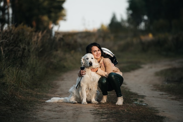 meisje knuffelen een golden retriever-hond in het bos