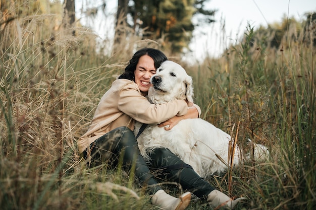 meisje knuffelen een golden retriever-hond in het veld