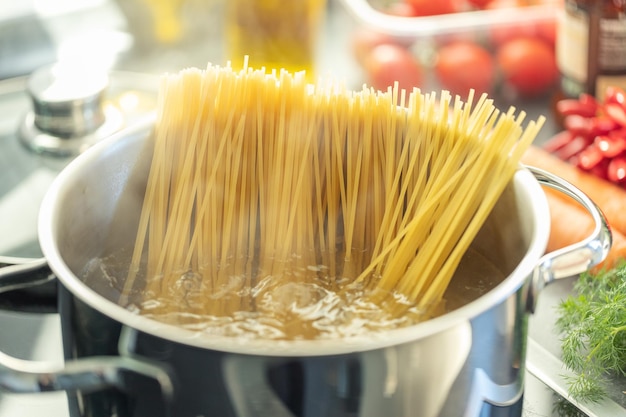 Meisje kookt pasta spaghetti in pot