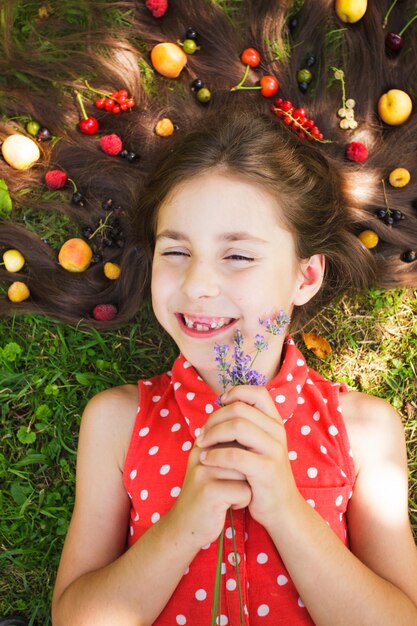 Meisje lag op het gras in de zomerdag, fruit en lavendel