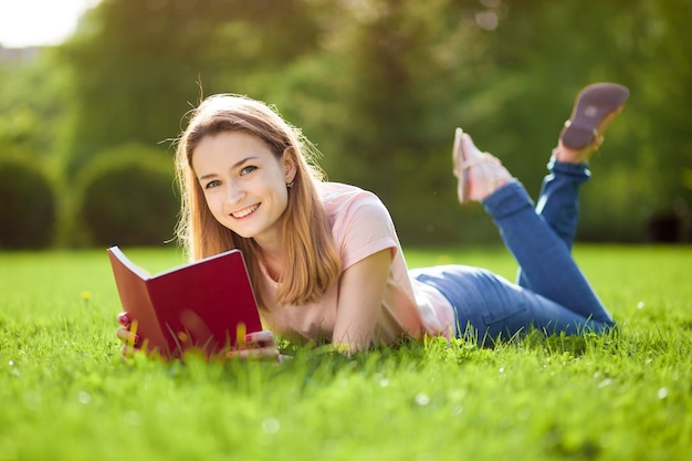 Meisje leesboek liggend op het gazon