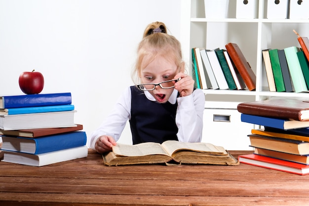 Meisje leest boeken aan de tafel