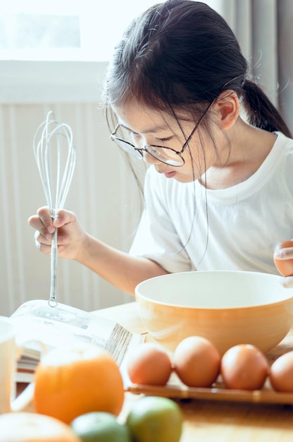Meisje leest een boek terwijl ze thuis eten bereidt