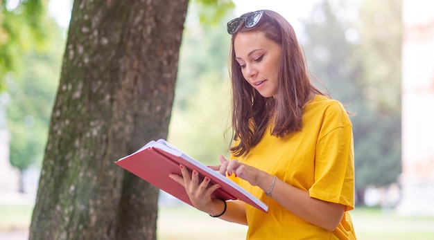 Meisje leest een rood boek in een park in de lente