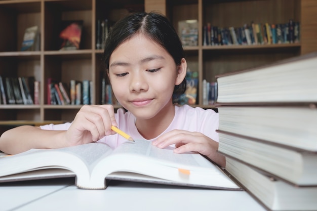 Meisje lezen en schrijven in de bibliotheek van school.