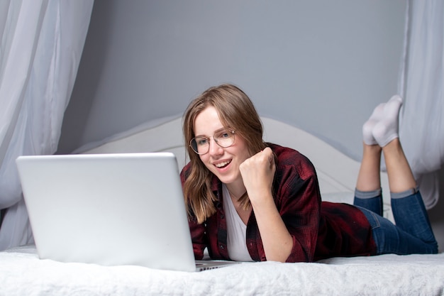 Meisje liggend in bed met een laptop