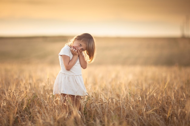 Meisje loopt in het veld met rogge bij zonsondergang levensstijl