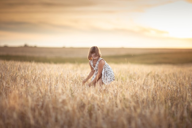 Meisje loopt in het veld met rogge bij zonsondergang levensstijl