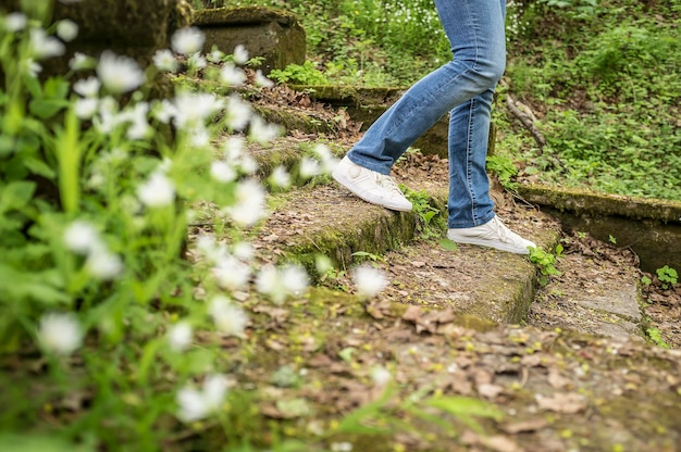 Foto meisje loopt langs de oude trappen begroeid met mos en gras in een bospark