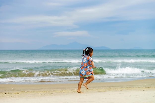 Meisje loopt langs het China Beach in Danang in Vietnam. Het wordt ook Non Nuoc Beach genoemd. Zuid-Chinese Zee op de achtergrond.