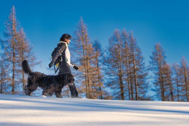 Meisje loopt met haar hond in de sneeuw